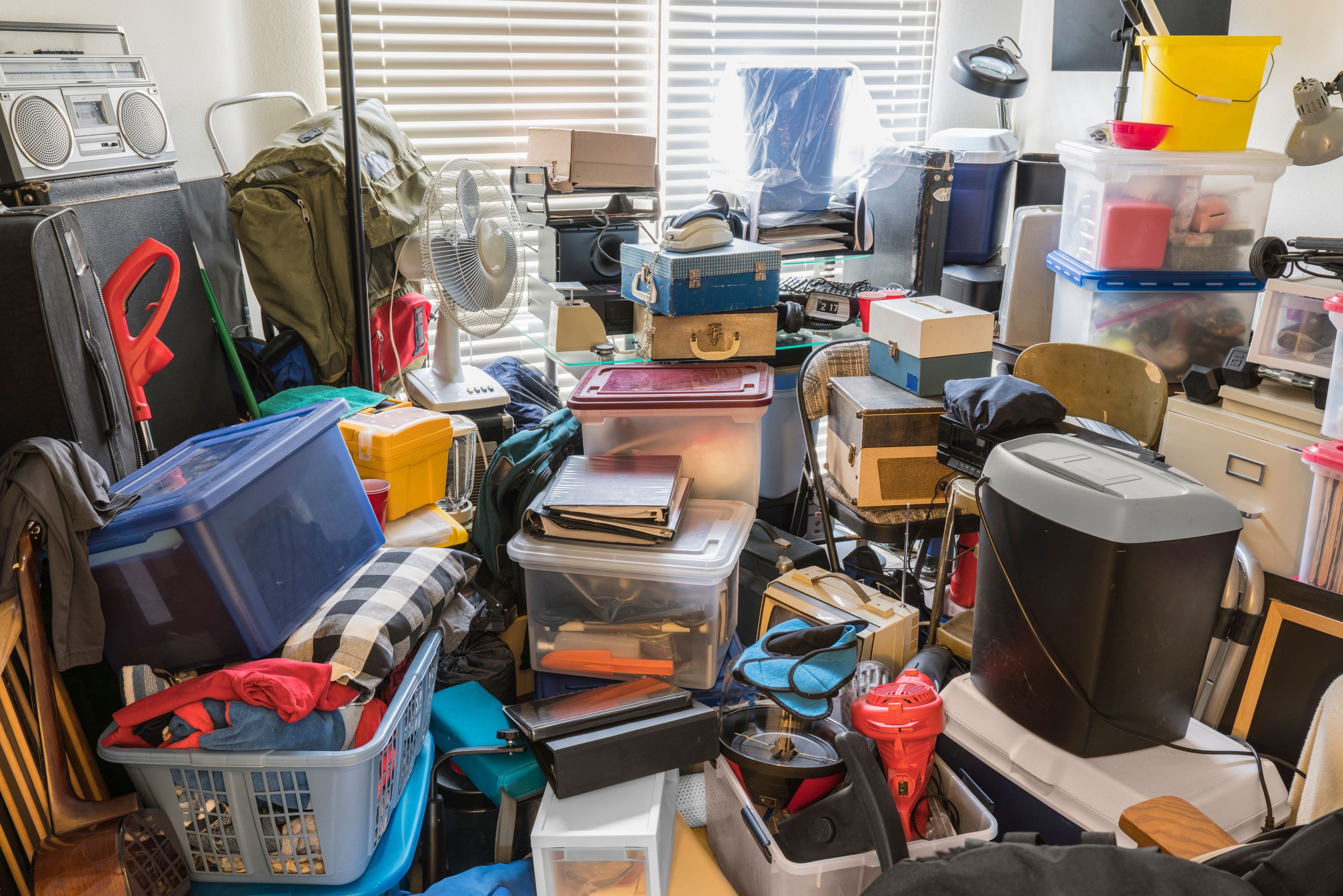 Hoarder room packed with boxes, electronics, business equipment, and household objects