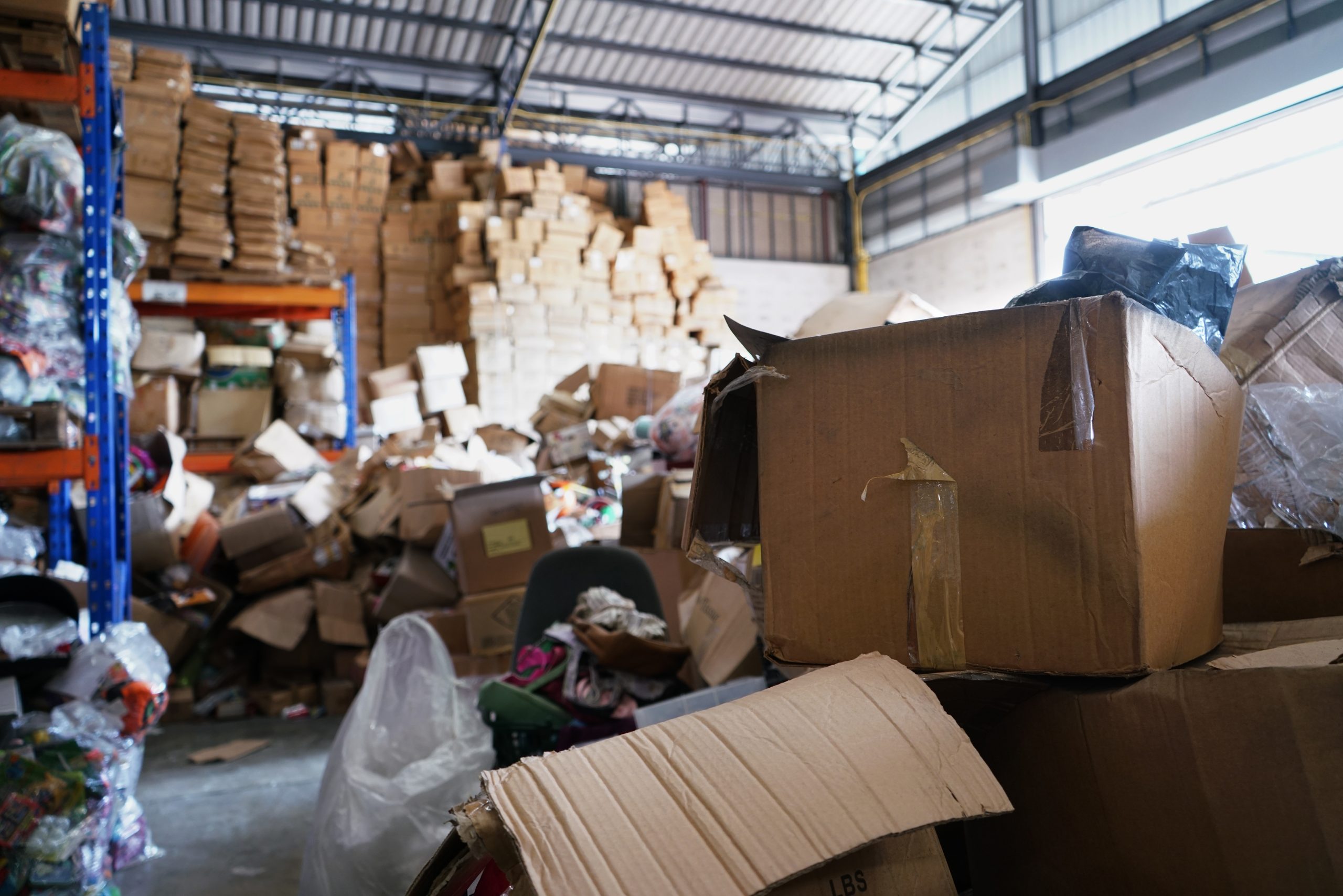 Poorly organized warehouse with a lot of messy stocks and clutter, illustrating the need for professional property cleanout services.