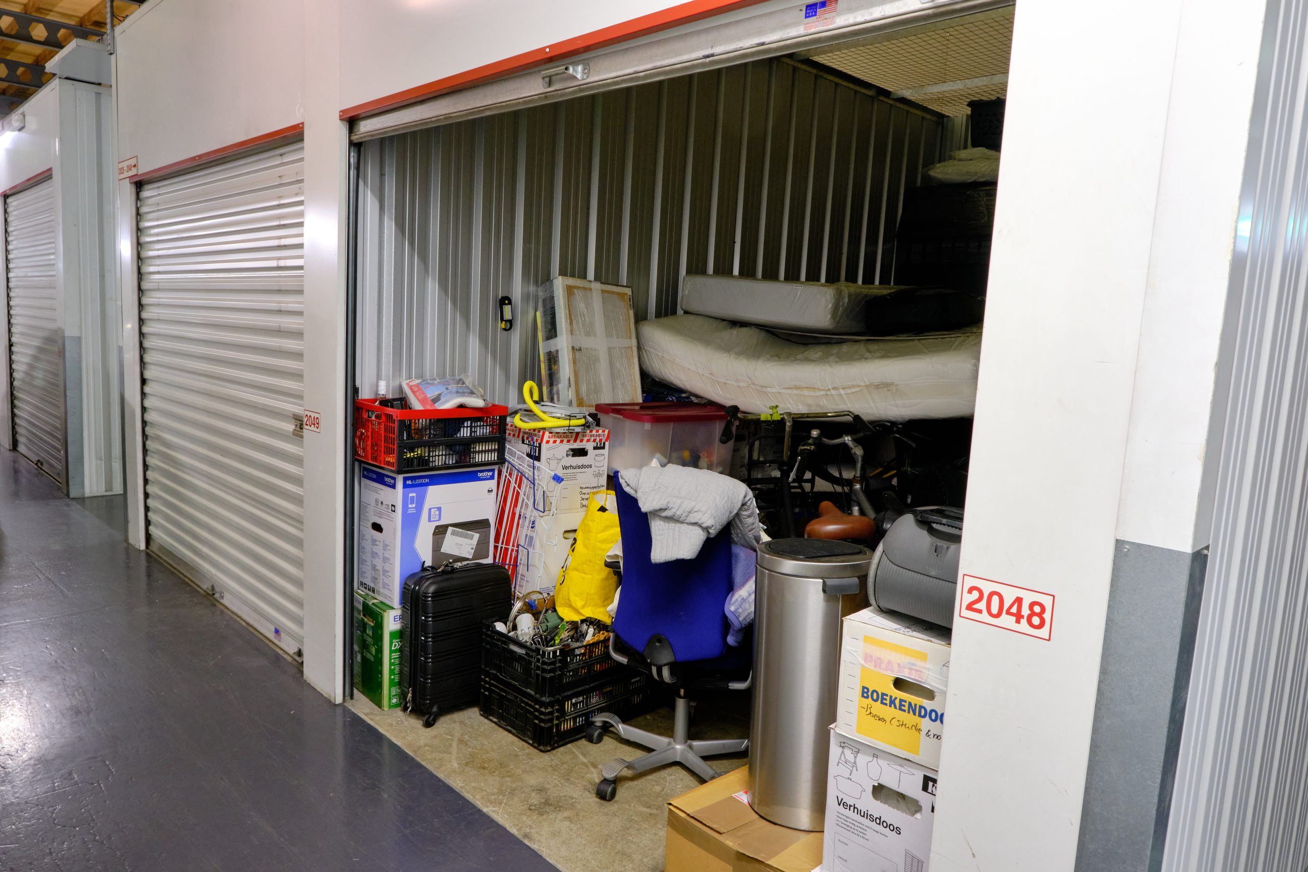 Indoor storage unit with open door and household items, ideal for property cleanout and junk removal services.