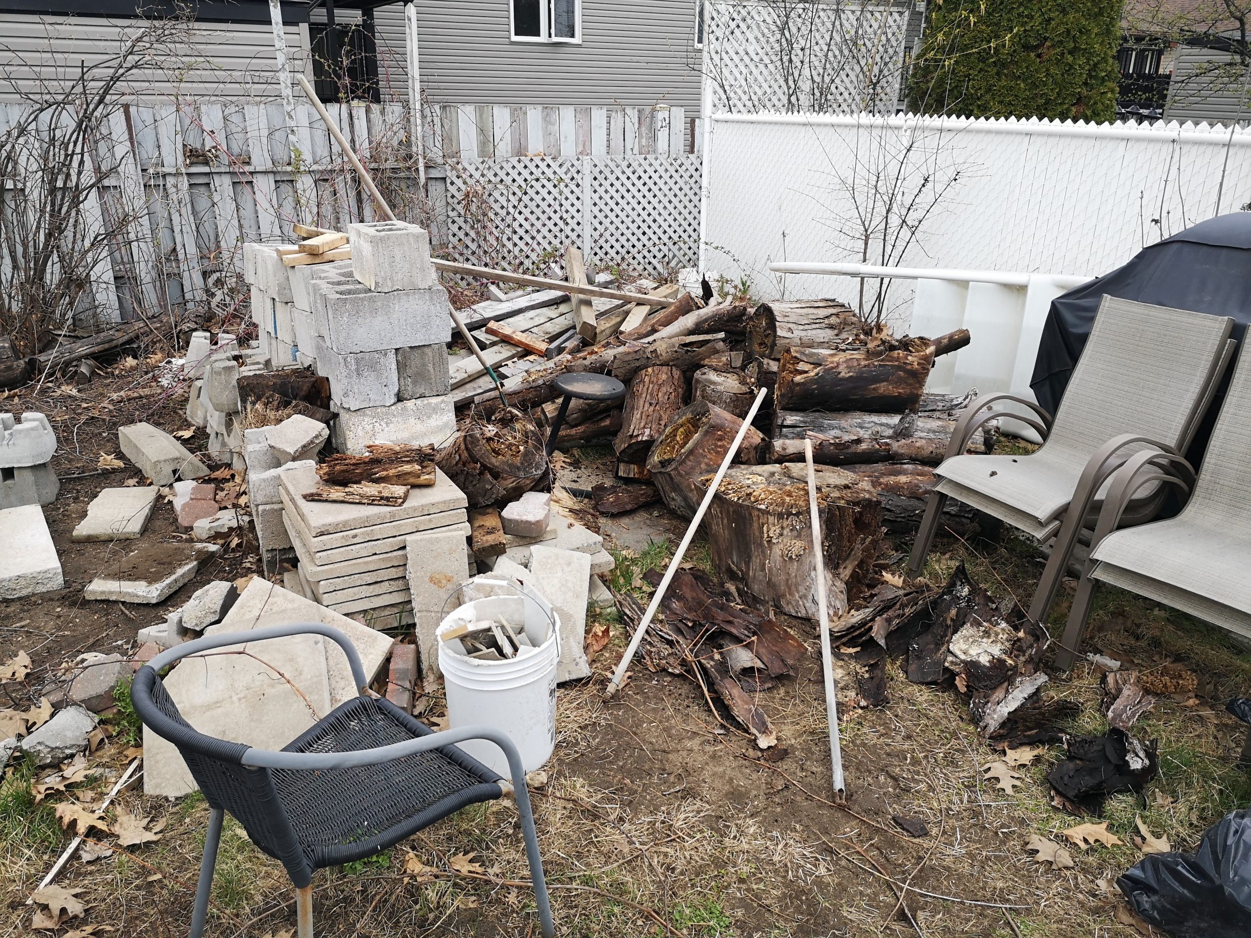 Example of a very messy backyard with piled debris, ideal for property cleanout and junk removal services.