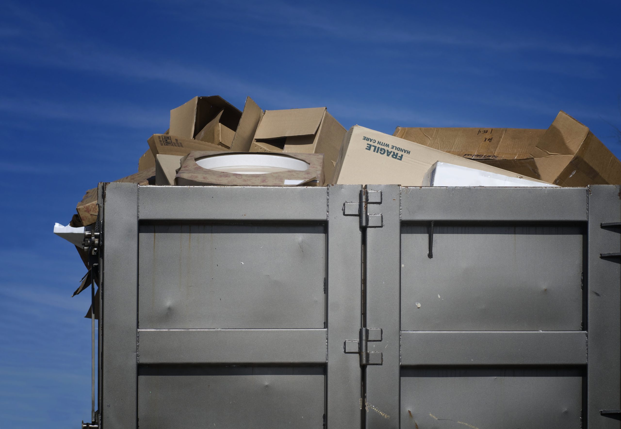 Overflowing garbage bin with trash spilling out