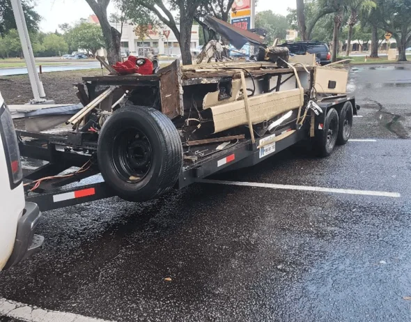 Open truck filled with various junk and dismantled furniture