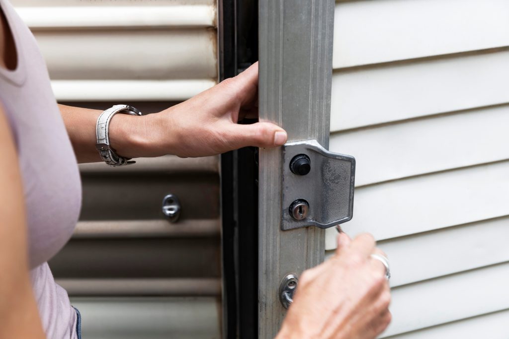 Woman's hand using a key to unlock a storage room, illustrating a scenario ideal for property cleanout and junk removal services.