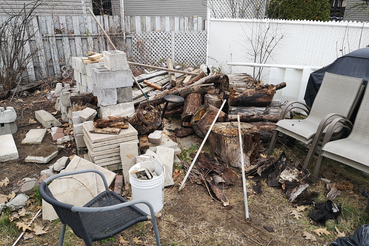 Example of a very messy backyard with piled debris, ideal for property cleanout and junk removal services.